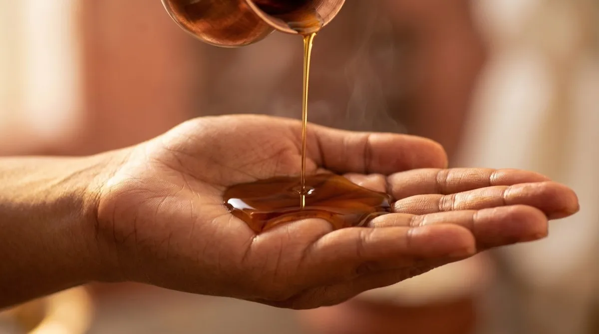 Warm herbal oil on an open palm
